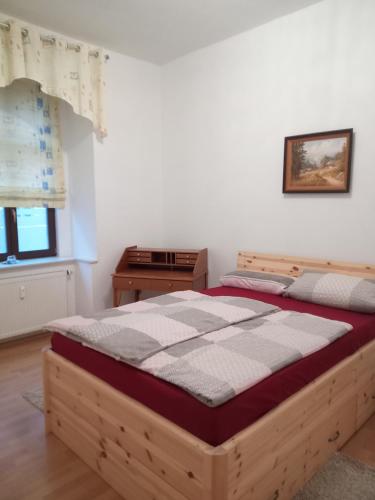 a bedroom with a wooden bed in a room at Zum Senckenberg by Satischni in Görlitz