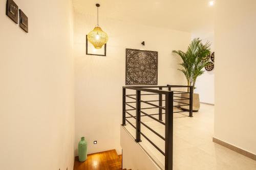 a staircase in a living room with a light fixture at Zayana Villas Resort Seminyak in Seminyak