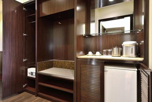a kitchen with wooden cabinets and a sink and a refrigerator at EXES Ishigaki in Ishigaki Island