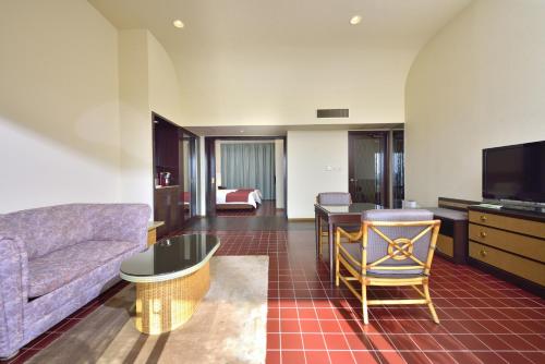 a living room with a couch and a tv at EXES Ishigaki in Ishigaki Island