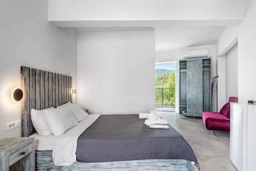 a bedroom with a large bed and a red chair at Papatsas Center Houses in Nydri