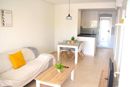 een woonkamer met een witte bank en een tafel bij Oasis Holiday House in Orihuela