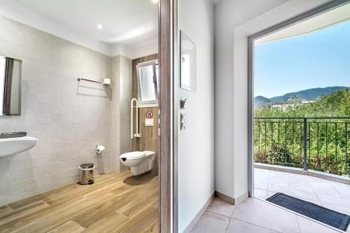 a bathroom with a sink and a toilet and a balcony at Papatsas Center Houses in Nydri