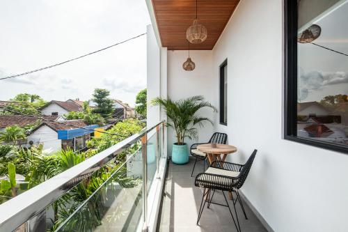a balcony with two chairs and a table on it at Zayana Villas Resort Seminyak in Seminyak