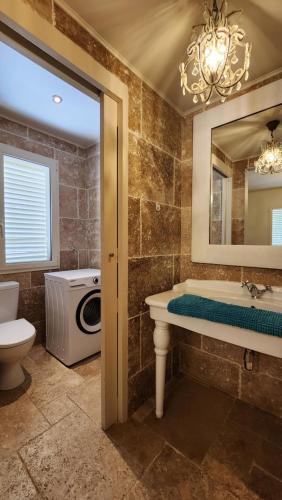 Your Cozy Vacation House في كراليندايك: حمام مع حوض ومرحاض ومرآة
