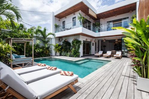 a villa with a swimming pool and a house at Zayana Villas Resort Seminyak in Seminyak
