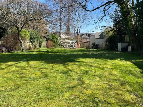 a large grass yard with trees and houses at Portland House in Whitchurch