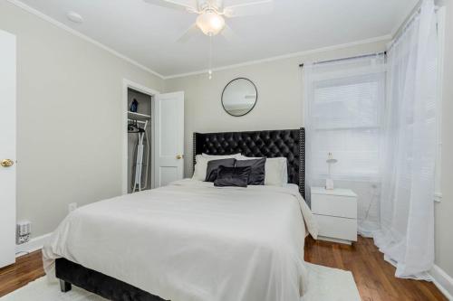 um quarto branco com uma cama grande e uma ventoinha de tecto em Minutes away from Downtown area em Charlotte