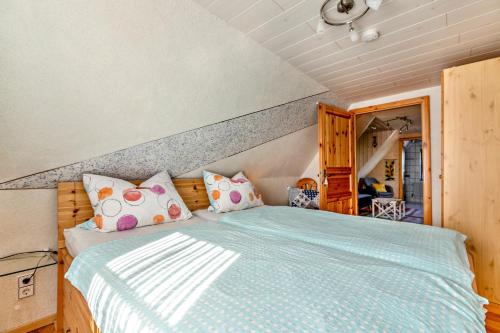 Schlafzimmer mit einem Bett mit blauer Decke in der Unterkunft Ferienhaus Riedel in Galmsbüll