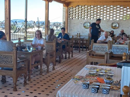 Hotel Zarhal في بوكسورو: مجموعة من الأشخاص يجلسون على الطاولات في مطعم