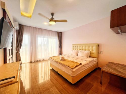 a bedroom with a large bed with a ceiling fan at Billiards And Karaoke, Free Pickup in Sengkuang