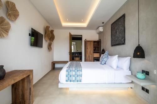 a bedroom with a white bed in a room at Zayana Villas Resort Seminyak in Seminyak