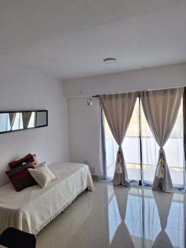 Habitación blanca con 2 camas y ventanas grandes. en Departamento Pueyrredón Salta Argentina en Salta