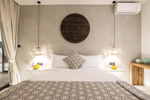 a bedroom with a large bed and two lamps at Zayana Villas Resort Seminyak in Seminyak