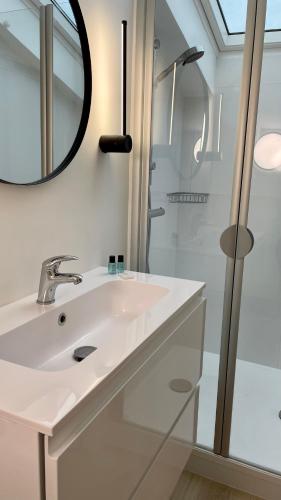 une salle de bain blanche avec un lavabo et une douche dans l'établissement Le Monceau - Charmant appartement mezzanine Paris, à Paris