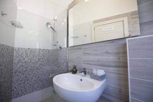 a bathroom with a white sink and a mirror at Hotel Elite in Cervia