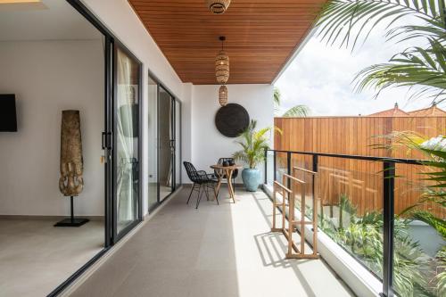an open balcony with a table and chairs on it at Zayana Villas Resort Seminyak in Seminyak