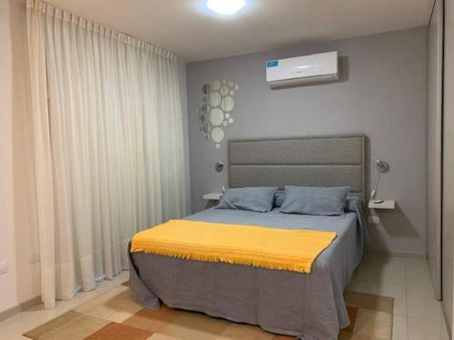 um quarto com uma cama com um cobertor amarelo em Departamento Opera Torre 2 em Villa Carlos Paz
