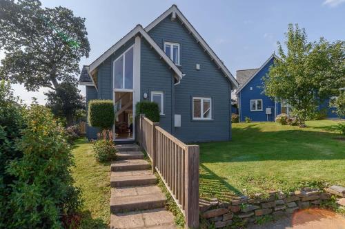 a blue house with a fence in front of it at Trewhiddle Retreat V7 by Together Travel - Luxury 3-Bedroom Villa in St Austell