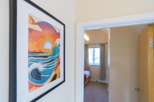 a painting on the wall of a room with a bedroom at Trewhiddle Villa 07 in St Austell