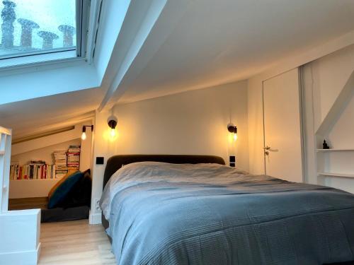 une chambre avec un grand lit dans une pièce dans l'établissement Le Monceau - Charmant appartement mezzanine Paris, à Paris