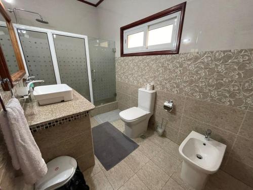 a bathroom with a toilet and a sink and a mirror at Bethel's Villas in La Digue