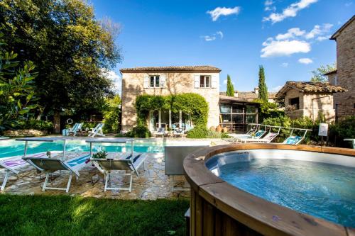 een zwembad met stoelen en een huis bij Castello di Granarola - Dimora storica, Suites e Appartamenti in Gradara