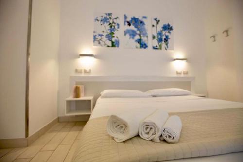 a bedroom with a white bed with towels on it at Hotel Elite in Cervia