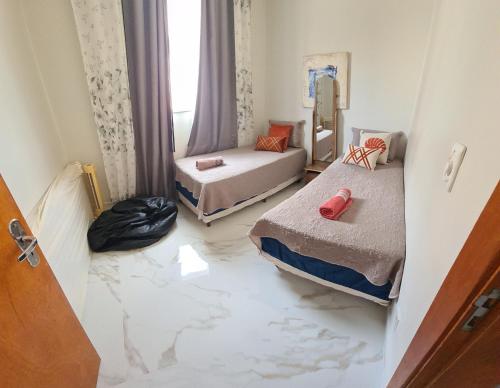 a room with two beds and a marble floor at Apartamento in Capitólio