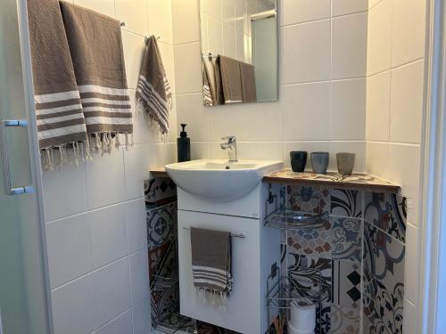 ein Bad mit einem Waschbecken und einem Spiegel in der Unterkunft Endless Sunset in Pendakomo