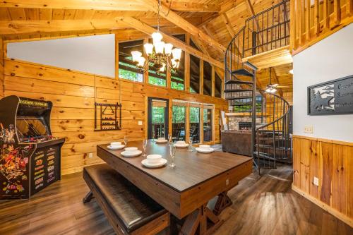 ein Esszimmer mit einem großen Holztisch und einer Treppe in der Unterkunft Bear Bottom Cabin in Gatlinburg