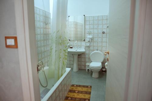 a bathroom with a toilet and a sink and a tub at BELVEDERE Appartamento per vacanze in Castel di Iudica