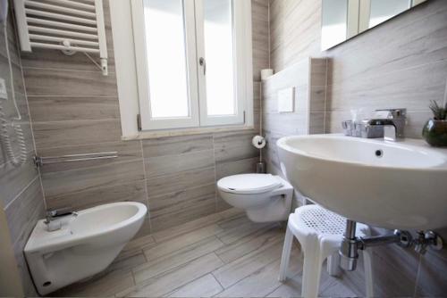 a bathroom with a white sink and a toilet at Hotel Elite in Cervia