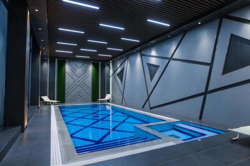 a swimming pool with a blue tile floor in a building at PREMIER HOTEL in Andijan