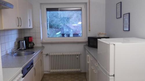 eine Küche mit einem weißen Kühlschrank und einem Fenster in der Unterkunft Fuchsmichelhof 4 in Seebach