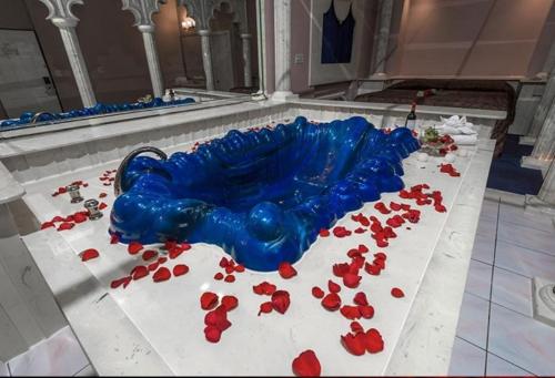 a blue glass bottle sitting on a table with red roses at Loop Inn Motel in Avenel