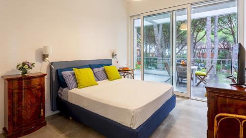 ein Schlafzimmer mit einem Bett mit gelben Kissen in der Unterkunft LA VILLA IN PINETA 10, Emma Villas in Castiglione della Pescaia