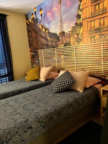 1 dormitorio con 2 camas y un mural de la torre Eiffel en The Loft E&E Orient Express, en Empoli