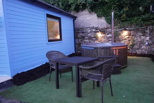 Baltinglass的住宿－West Wicklow Glamping with Hot Tub，桌子和两把椅子,桌子和桶