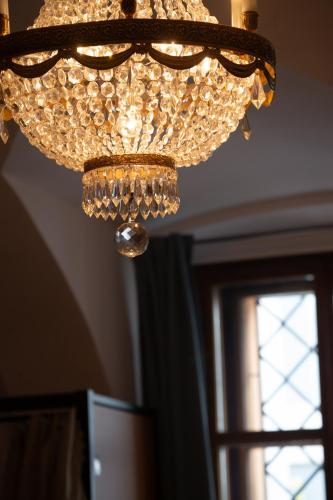 a chandelier hanging from a ceiling with a window at Women's Only Hostel - Female Only in Prague