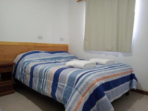 a bedroom with a bed with two towels on it at Chaltén Apart 365 in El Chalten