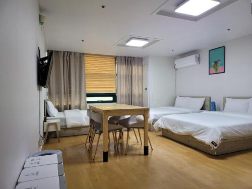 sypialnia z 2 łóżkami, stołem i biurkiem w obiekcie SHseoul w Seulu