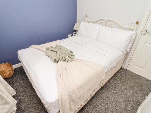 a white bed in a room with a blue wall at Tivoli in Retford