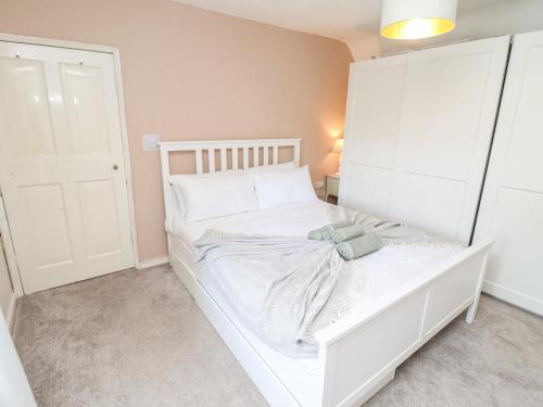 a small white bed in a room with a door at Tivoli in Retford