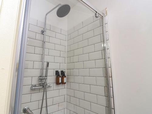 a bathroom with a shower with white tiles at Tivoli in Retford