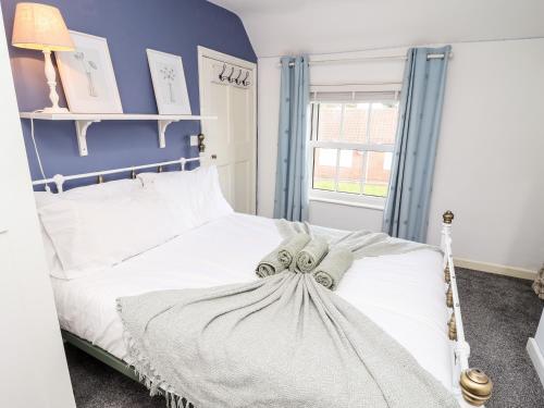 a bedroom with a white bed with a blue wall at Tivoli in Retford