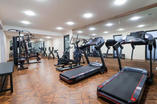 a gym with several treadmills and elliptical machines at PREMIER HOTEL in Andijan