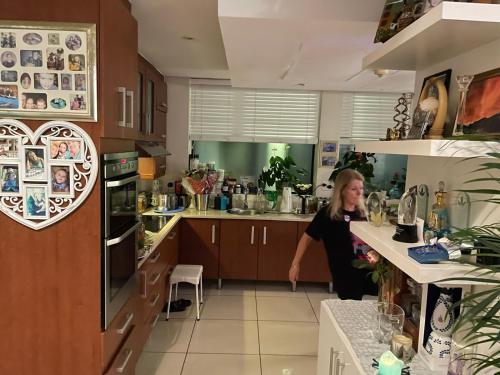 Una mujer parada en una cocina con una barra en DNA Dream Home, en Durban