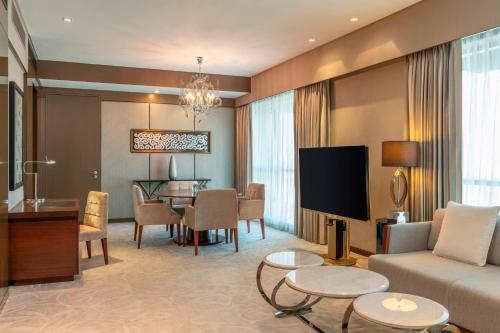 a living room with a couch and a dining room at Le Meridien City Centre Bahrain in Manama
