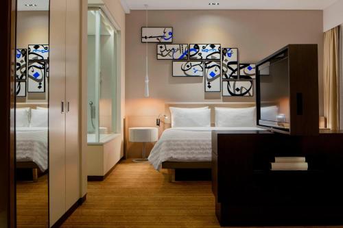 a hotel room with a bed and a mirror at Le Meridien City Centre Bahrain in Manama